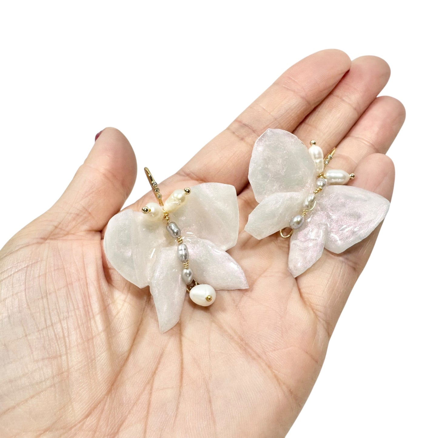 Handcrafted butterfly-shaped earrings in pearl white, made from upcycled materials and finished in a luminous White Silk tone.