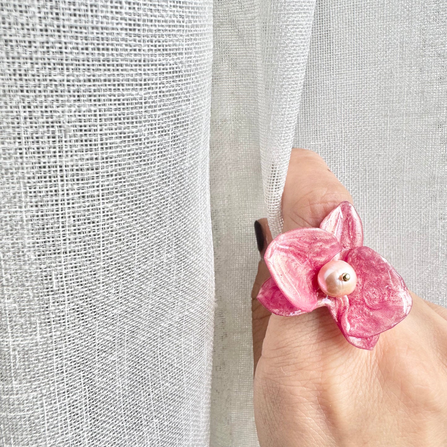 Handcrafted orchid flower ring in soft powder pink, made from upcycled materials with a velvet-like finish.