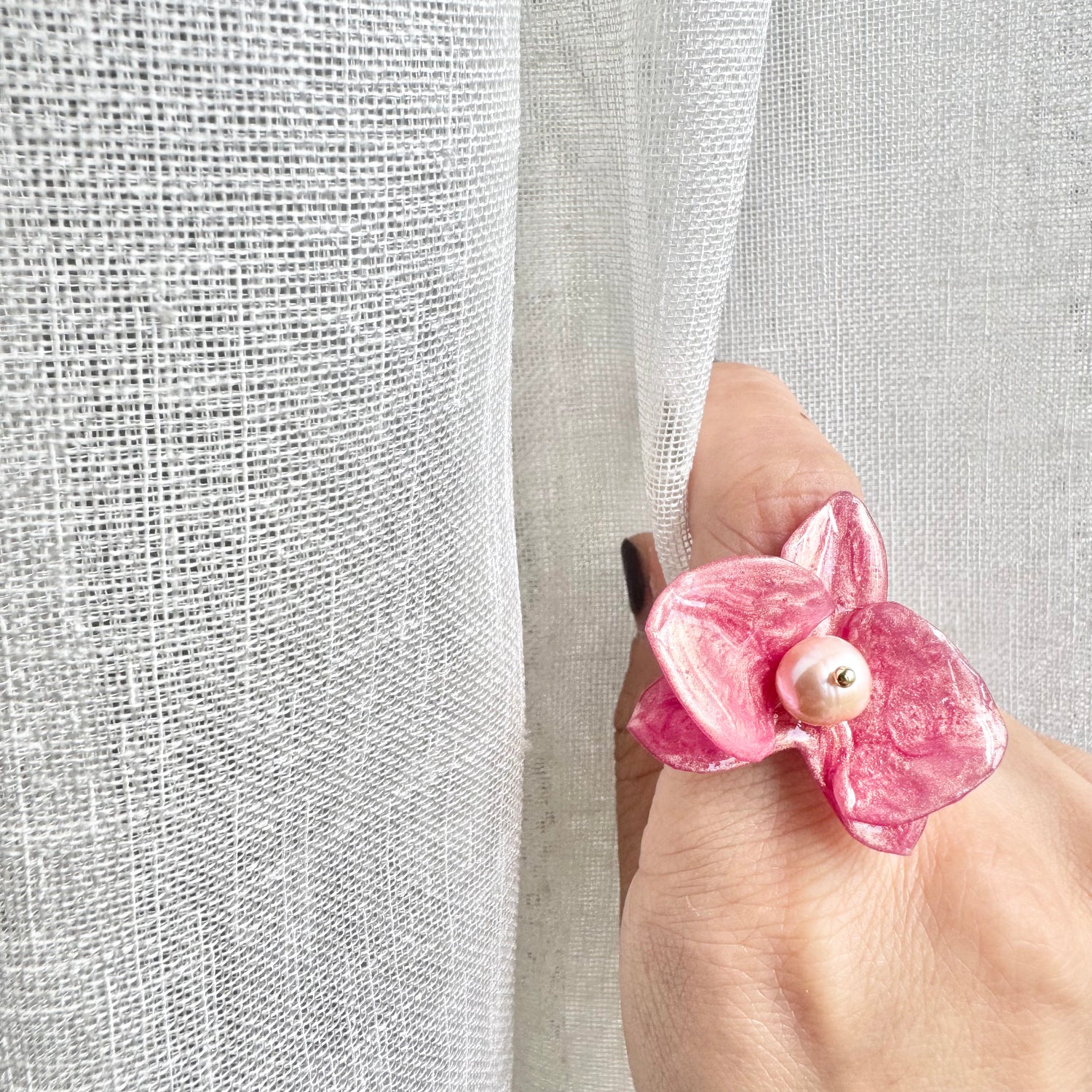 Handcrafted orchid flower ring in soft powder pink, made from upcycled materials with a velvet-like finish.