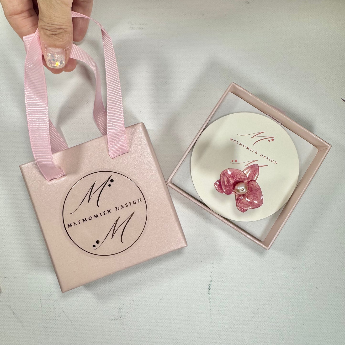 Handcrafted orchid flower ring in soft powder pink, made from upcycled materials with a velvet-like finish.