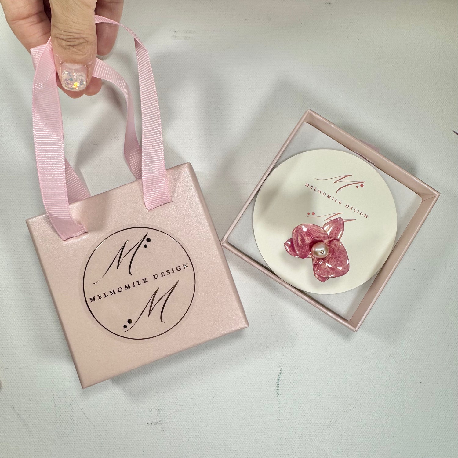 Handcrafted orchid flower ring in soft powder pink, made from upcycled materials with a velvet-like finish.