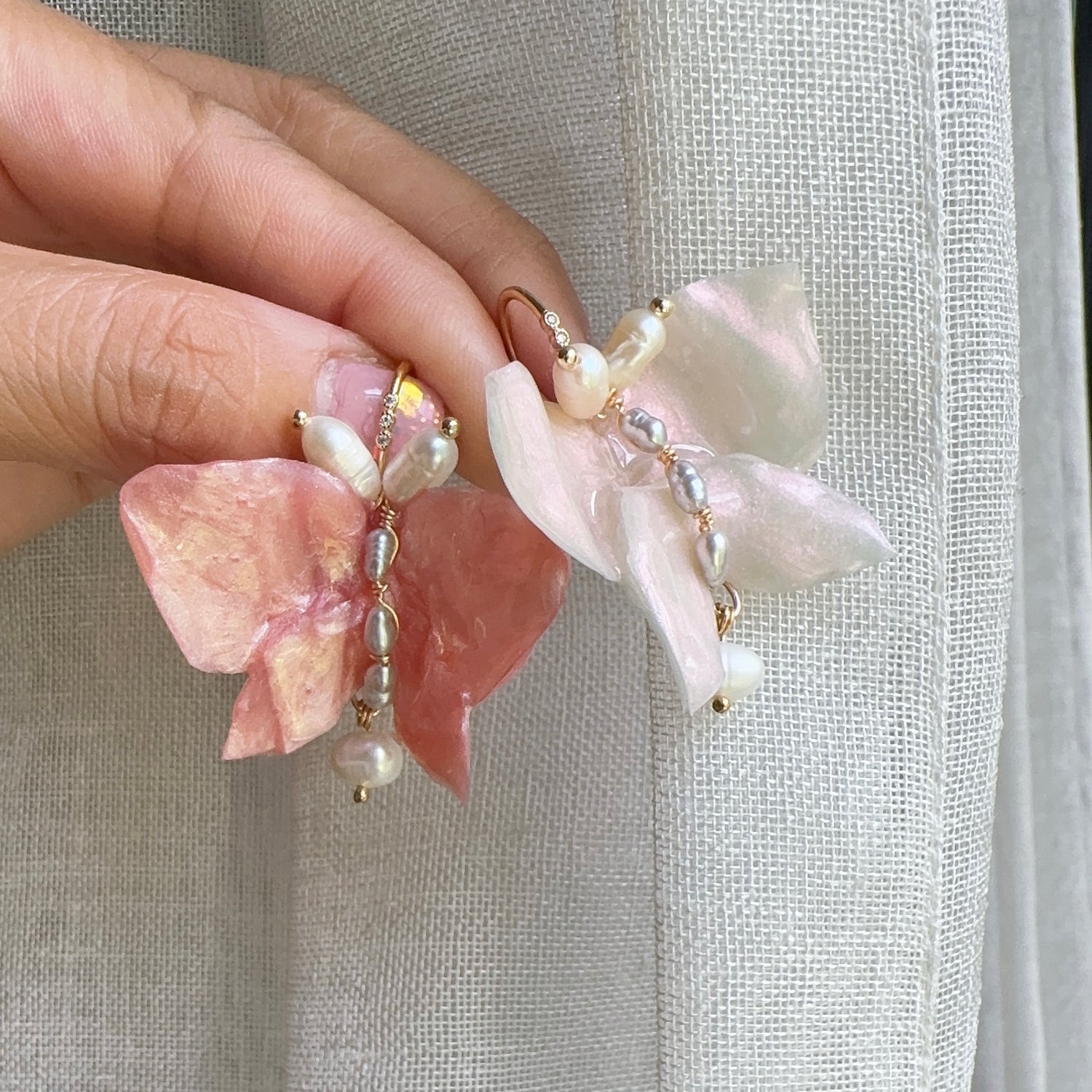 Handcrafted butterfly-shaped earrings in pearl white, made from upcycled materials and finished in a luminous White Silk tone.