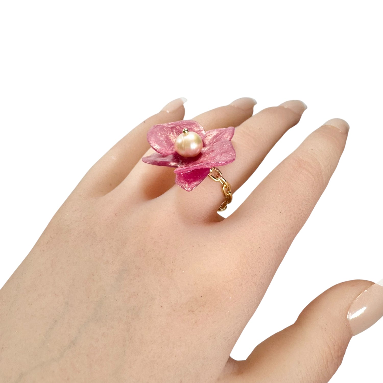Handcrafted orchid flower ring in soft powder pink, made from upcycled materials with a velvet-like finish.