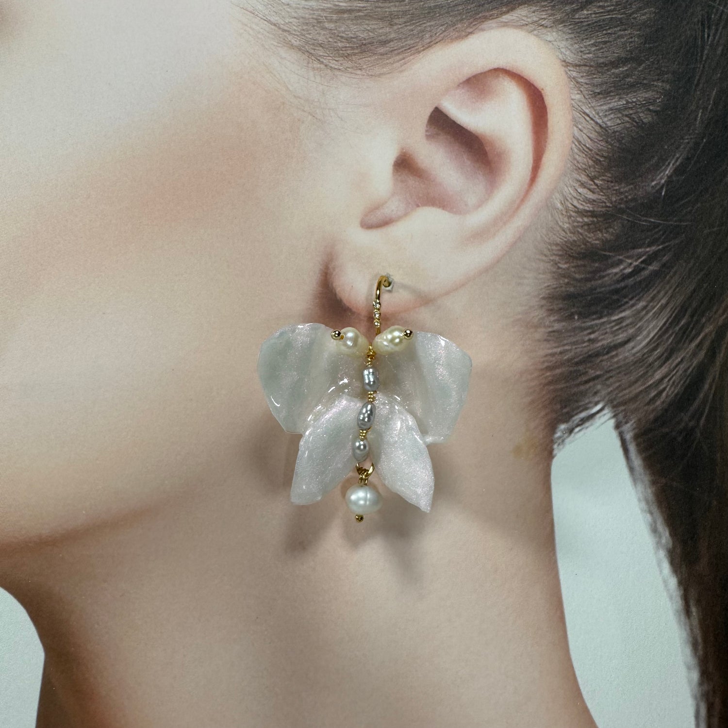 Handcrafted butterfly-shaped earrings in pearl white, made from upcycled materials and finished in a luminous White Silk tone.
