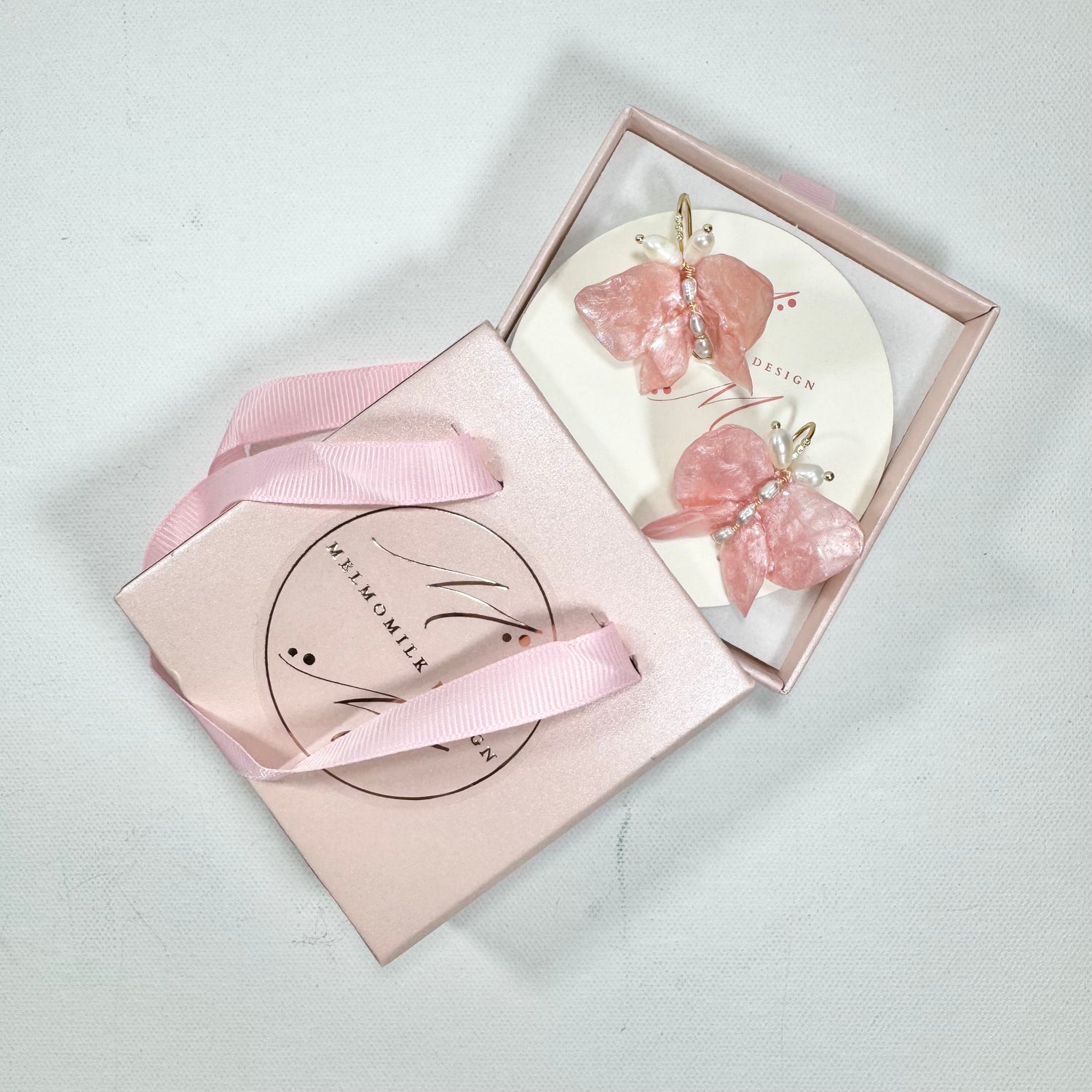 Soft pink butterfly earrings made from upcycled materials, featuring a romantic Pink Chiffon finish and delicate handmade detailing.