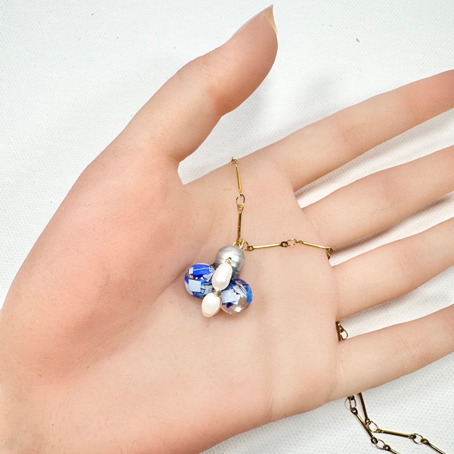 Bee Divine blue bee necklace with fresh water pearls handcrafted from upcycled plastic, featuring delicate bee-inspired designs with lightweight, eco-friendly materials. A sustainable statement piece for nature lovers.