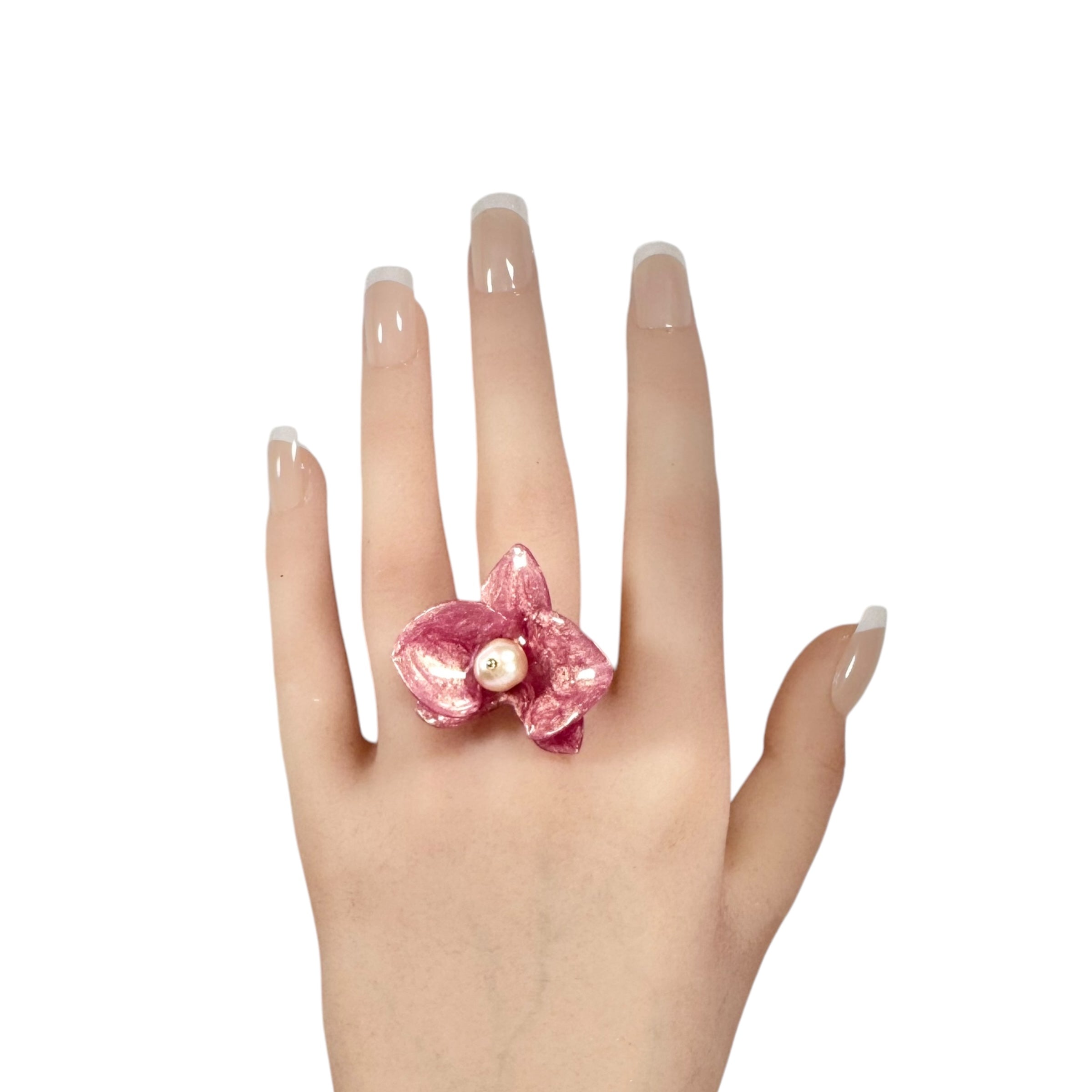 Handcrafted orchid flower ring in soft powder pink, made from upcycled materials with a velvet-like finish.
