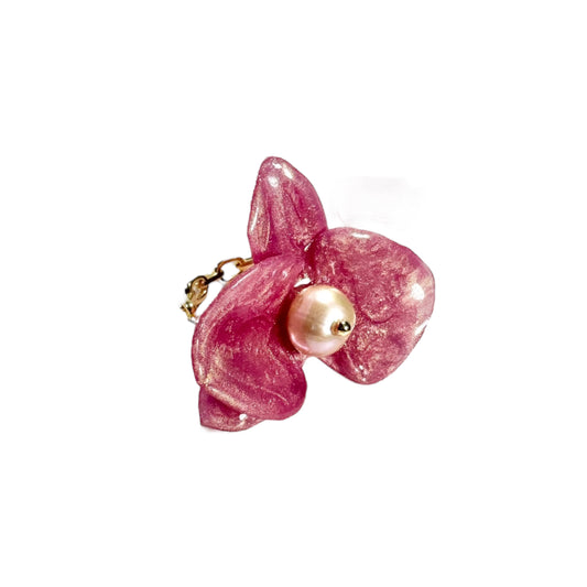 Handcrafted orchid flower ring in soft powder pink, made from upcycled materials with a velvet-like finish.
