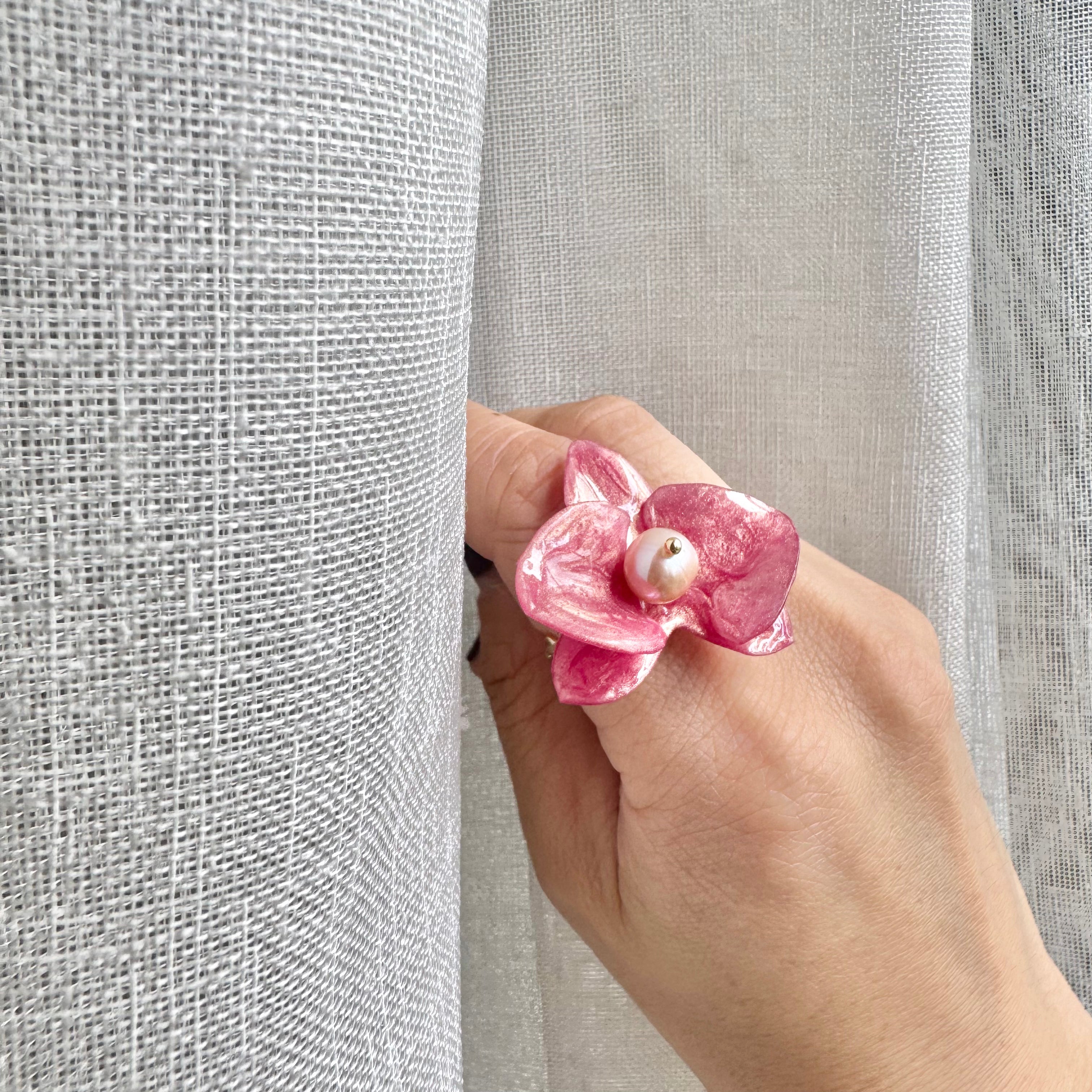 Handcrafted orchid flower ring in soft powder pink, made from upcycled materials with a velvet-like finish.
