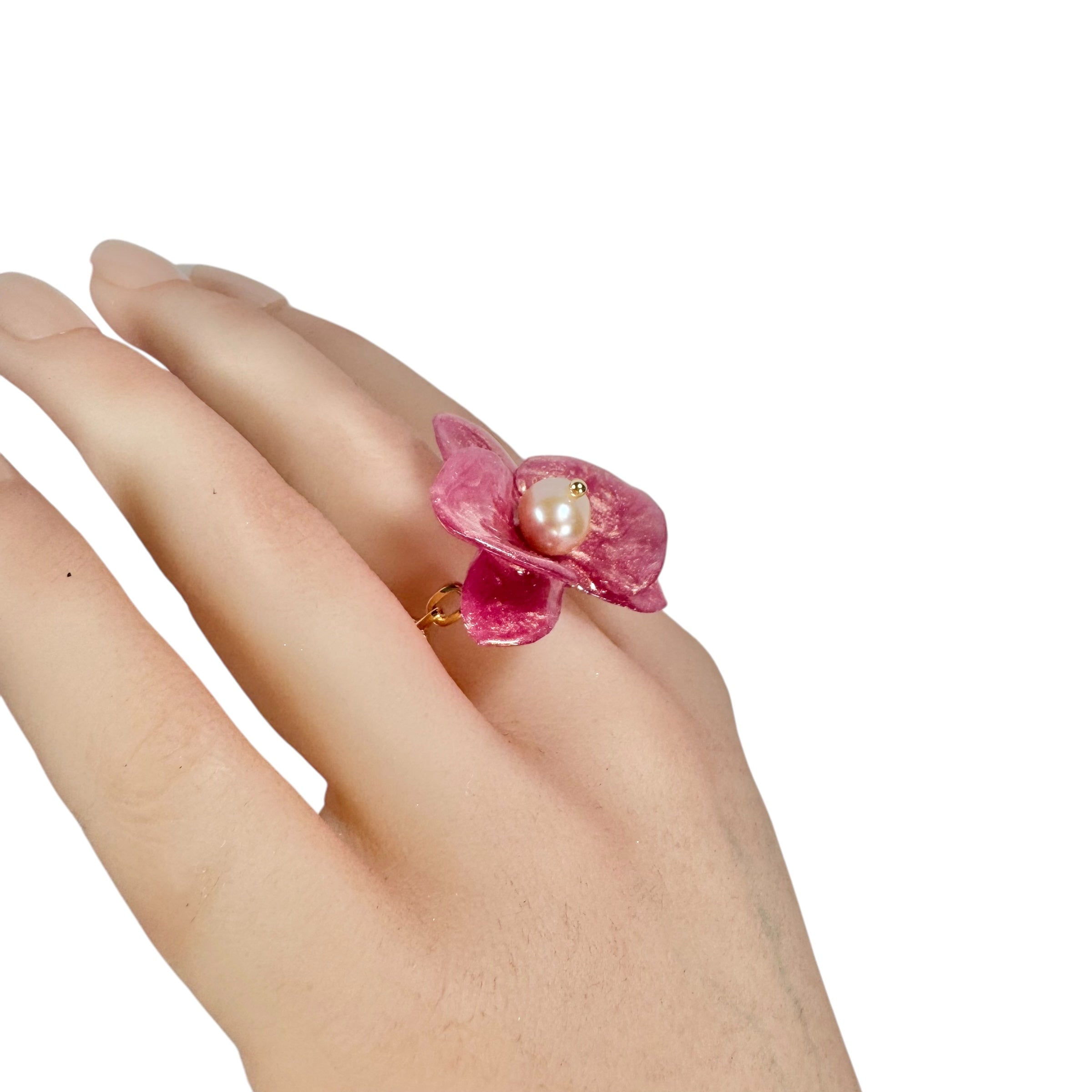 Handcrafted orchid flower ring in soft powder pink, made from upcycled materials with a velvet-like finish.
